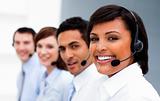 Ethnic businesswoman with headset on smiling at the camera 