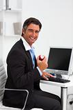 Smiling businessman holding a red apple