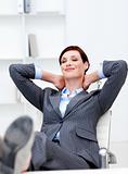 Businesswoman sitting in office with feet on desk relaxing 