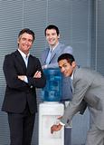 Portrait of a business team filling cup from water cooler