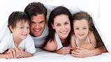 Portrait of a smiling family lying on bed