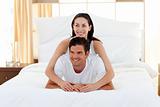 Smiling couple playing on bed together