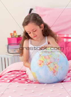 Little girl having fun with a terrestrial globe