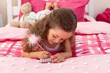 Close-up of a Little girl writing on bed