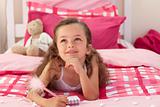 Smiling girl writing on bed