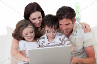 Family using a laptop on the sofa