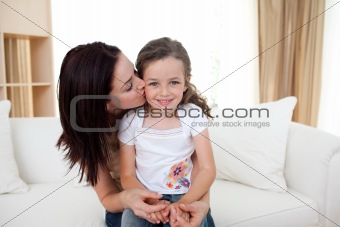 Attentive mother kissing her little girl