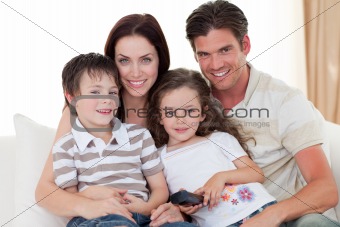 Young family watching TV on the sofa
