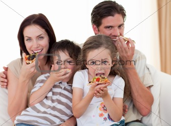 Happy family eating pizza in living-room all together