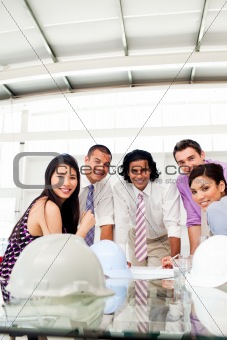 Architects smiling at the camera in a meeting