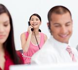 Smiling businesswoman on phone with her colleagues in the foregr
