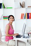 Smiling businesswoman with headset on in the office