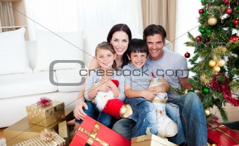 Young family having fun with Christmas presents at home