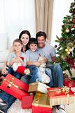 Young family having fun with Christmas presents at home