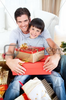 Happy father and son holding Christmas gifts