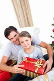 Smiling little girl with her father holding a Christmas gift
