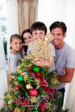 Happy family decorating a Christmas tree