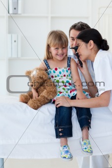 Serious patient examing littl girl's ears