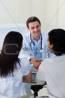 Smiling doctor explaining diagnosis to a couple