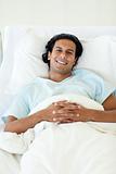 Portrait of a smiling patient lying in a hospital bed