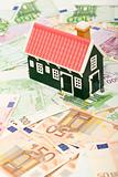 Miniature house on euro banknotes field