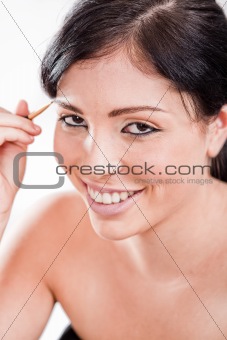 Young woman applying eyebrow pencil