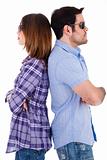 Young couple standing back to back wearing sunglasses