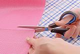 Dressmaker cuts scissors fabrics