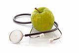  Stethoscope and green apple on white background