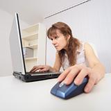 Young woman with concentration works in Internet on computer