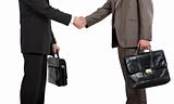 Two businessmen holding briefcases and shaking hands