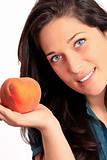 Beautiful young girl holding a peach.