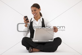 Young Woman Using Laptop and Cell Phone