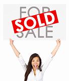 Real estate woman holding sold sign