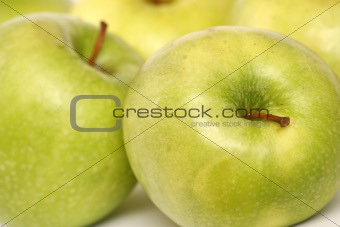 Many green apples on a white background