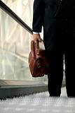 Businessman with briefcase on escalator