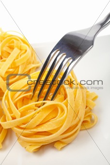 Uncooked pasta nests and fork