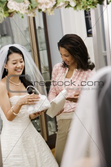 Woman helping bride with handbags.