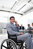 Smiling businessman on phone sitting in a wheelchair