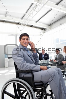 Smiling businessman on phone sitting in a wheelchair