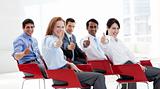 Business people with thumbs up at a conference
