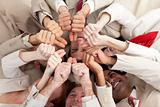 Successful business team with thumbs up lying in a circle