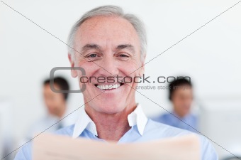 Smiling senior businessman reading 