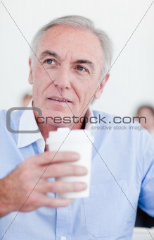 Senior businessman holding a drinking cup 