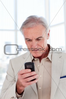 Concentrated senior businessman sending a text 