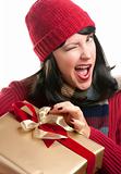 Happy, Winking, Attractive Woman Holds Holiday Gift Isolated on a White Background.
