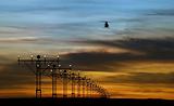 runway lights and silhouette of a helicopter
