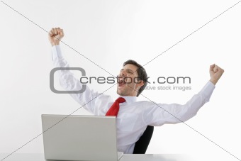 young business executive in white shirt behind desk cheering