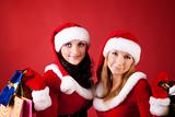 Two women in dressed as Santa, with shopping bags