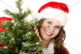 Young smiling Santa Woman standing beside Christmas tree 